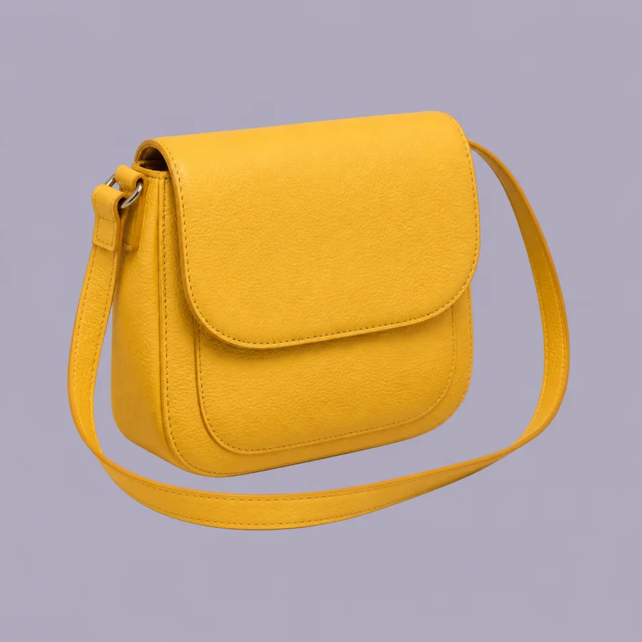 Yellow leather crossbody bag on a muted studio background before background removal.