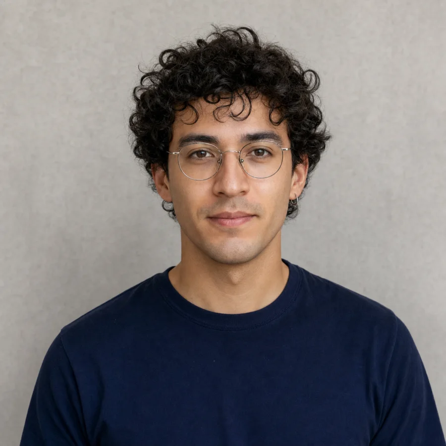 Illustrative source portrait with curly hair, glasses, an earring, and a collar edge to review before background removal.